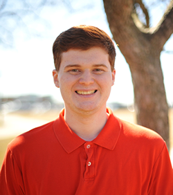 A professional headshot photo of Daniel Arini, a young student smiling in a summer backdrop outdoors