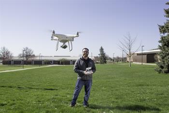 A drone instructor flies a drone via remote control.