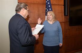 Gretchen Alaniz raises her right hand as she gets sworn in as trustee