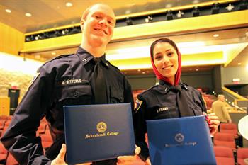 Two fire academy graduates proudly posing for the camera