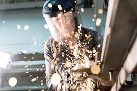 A person welding metal making a scene of sparks