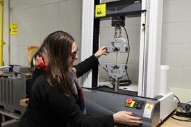 Young female student operating a plastics machinery