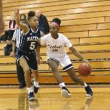 A Schoolcraft player dribbles the ball around an opponing guard